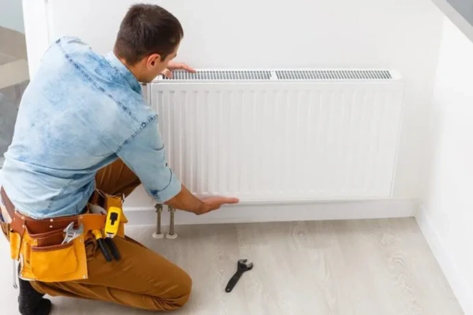 une personne qui installe un radiateur 